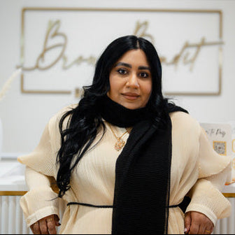 Woman standing in a stylish interior setting with decor elements.